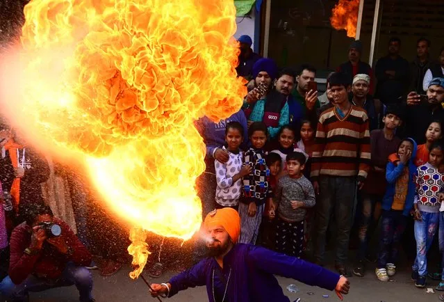 A Sikh performer demonstrate his skills during a religious procession ahead of the birth anniversary celebrations of the tenth Guru of the Sikhs, Guru Gobind Singh in Prayagraj on December 27, 2022. (Photo by Sanjay Kanojia/AFP Photo)