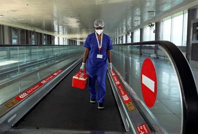 A laboratory technician carries swab samples collected from passengers amidst the spread of the coronavirus disease (COVID-19) at Indira Gandhi International Airport, in New Delhi, India, September 12, 2020. (Photo by Anushree Fadnavis/Reuters)