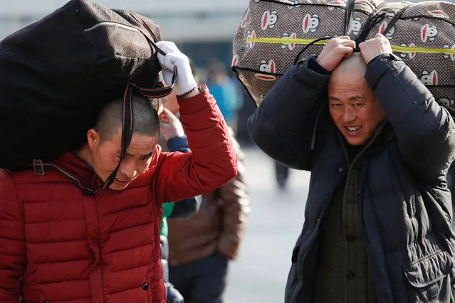 Passengers carry luggage toward the Beijing Railway Station as the annual Spring Festival travel rush begins ahead of the Chinese Lunar New Year, in central Beijing, China on February 1, 2018. (Photo by Damir Sagolj/Reuters)