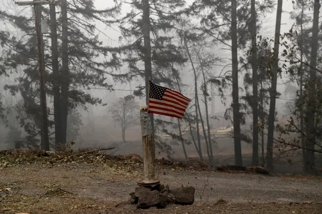 A U.S. flag is taped to the pole at the entrance of a house destroyed by fire in the aftermath of the Beachie Creek fire near Gates, Oregon, U.S., September 14, 2020. (Photo by Shannon Stapleton/Reuters)