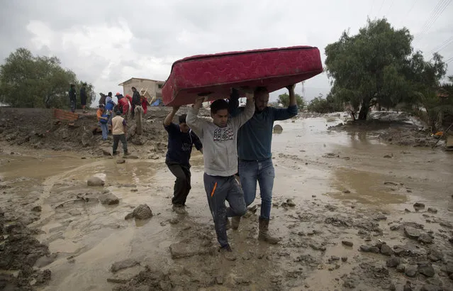Men carry a mattress they salvaged from a flooded home in Tiquipaya near Cochabamba, Bolivia, Thursday, February 8, 2018. The overnight swelling of the Taquina river damaged buildings and covered streets in mud and rubble in the small community, about 150 miles (250 kilometers) east of La Paz. (Photo by Juan Karita/AP Photo)