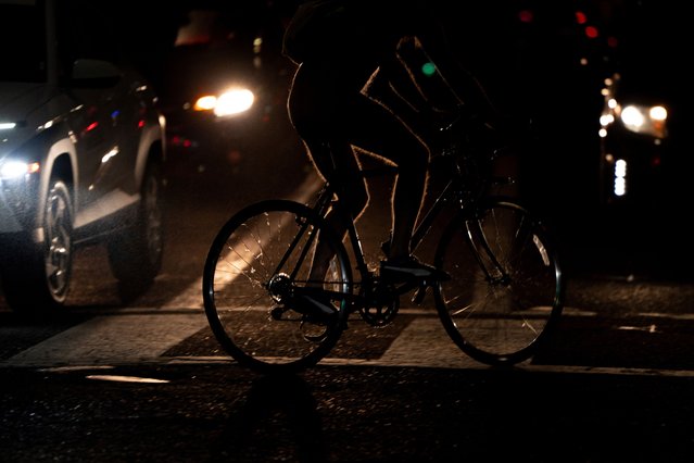Cars wait at an intersection as bikers pass by during Portland's World Naked Bike Ride protest on Saturday, July 26, 2025, in Portland, Ore. (Phoot by Jenny Kane/AP Photo)