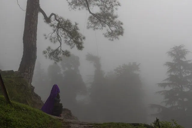 A woman walks under a thick fog in Dharmsala, India, Monday, August 10, 2020. (Photo by Ashwini Bhatia/AP Photo)