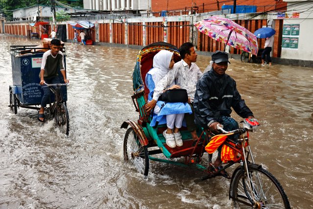 People ride on a rickshaw along a street flooded due to heavy rain, in Dhaka, Bangladesh, on July 15, 2025. (Photo by Mohammad Ponir Hossain/Reuters)