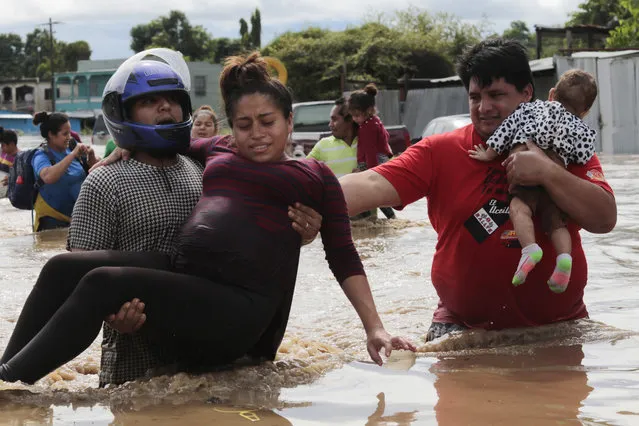 A pregnant woman is carried out of an area flooded by water brought by Hurricane Eta in Planeta, Honduras, Thursday, November 5, 2020. The storm that hit Nicaragua as a Category 4 hurricane on Tuesday had become more of a vast tropical rainstorm, but it was advancing so slowly and dumping so much rain that much of Central America remained on high alert. (Photo by Delmer Martinez/AP Photo)