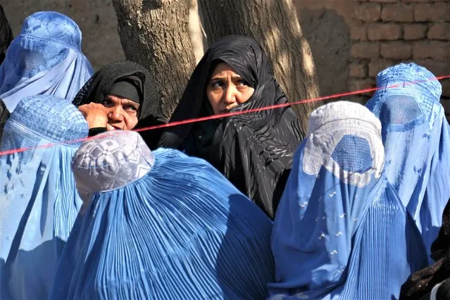 Afghan women wait to receive food aid from the Afghanistan Disaster Management, in Herat on March 2, 2023. (Photo by Mohsen Karimi/AFP Photo)