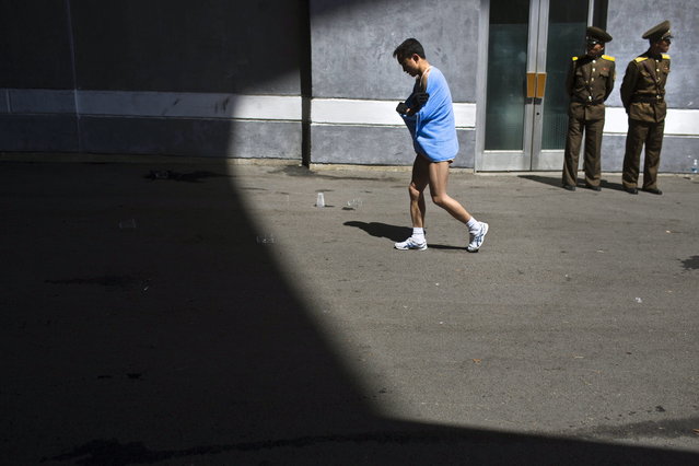 A marathon runner walks out of Kim Il Sung Stadium after completing the race in Pyongyang on Sunday, April 14, 2013. North Korea hosted the 26th Mangyongdae Prize Marathon to mark the upcoming April 15, 2013 birthday of the late leader Kim Il Sung. (Photo by Alexander F. Yuan/AP Photo)