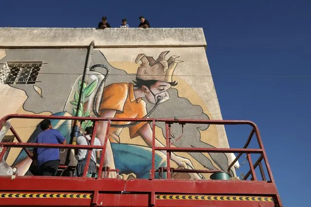 Jordanian artist, Yazan Mesmar, works on his mural on a building as part of the Baladk festival, which includes murals across Amman all with a message encouraging people to protect the environment, Jordan, October 13, 2020. (Photo by Muhammad Hamed/Reuters)