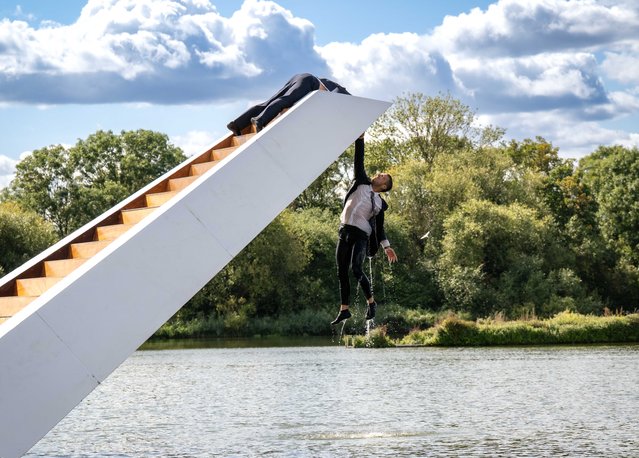 The Weight of Water, a modern parable of global warming set on an unpredictable floating staircase, takes place on Saturday at Birchmere Lake in Thamesmead, southeast London on September 5, 2025, as part of the Greenwich and Docklands International Festival. The show, from the Dutch company Panama Pictures, merges dance and circus as six performers struggle for survival. (Photo by John Nguyen)