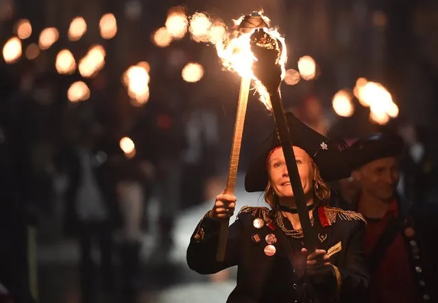 Participants in costume hold burning torches as they take part in one of a series of processions during Bonfire night celebrations in Lewes, southern England November 5, 2015. (Photo by Toby Melville/Reuters)