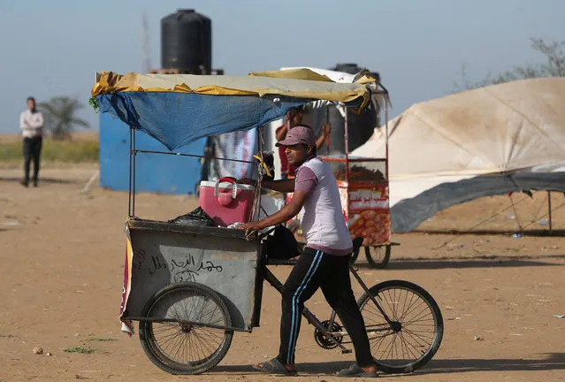 A Palestinian vendor pushes his cart during a tent city protest at Israel-Gaza border, in the southern Gaza Strip April 2, 2018. (Photo by Ibraheem Abu Mustafa/Reuters)