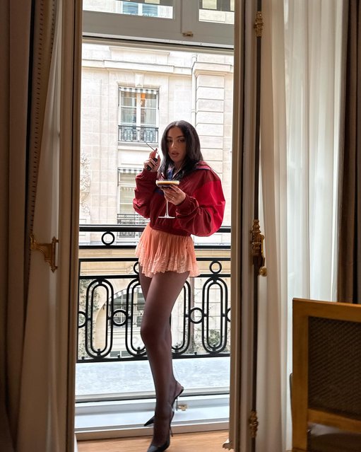 British singer-songwriter Charli XCX sips a martini from her balcony during Paris Fashion Week on September 29, 2025. (Photo by charli_xcx/Instagram)