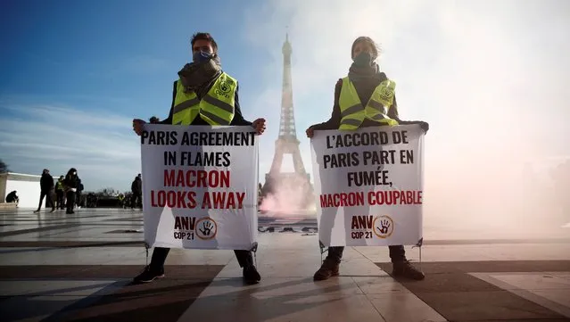Climate activists demonstrate in front of the Eiffel tower to mark the fifth anniversary of the 2015 United Nations Paris Agreement on climate change, in Paris, France, December 10, 2020. The slogan reads “Paris Agreement in flames, Macron looks away”. (Photo by Benoit Tessier/Reuters)