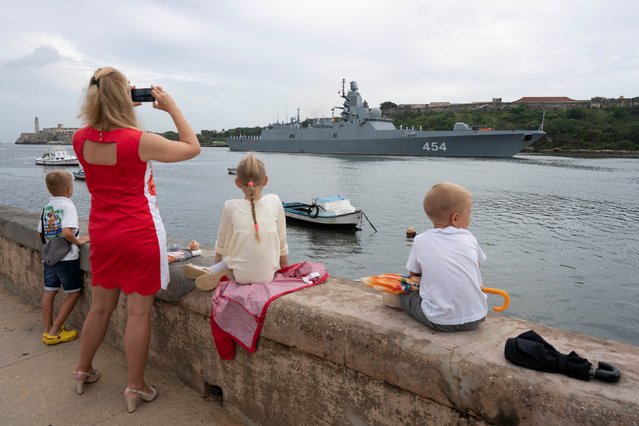 Members of the Russian community watch Russian frigate Admiral Gorshkov as it enters Havana’s bay, Cuba, on June 12, 2024. Small groups of fishermen and curious onlookers lined the Malecon seafront boulevard in light rain to welcome the ships as they passed the 400-year old Morro castle at the harbor's entrance. (Photo by Alexandre Meneghini/Reuters)