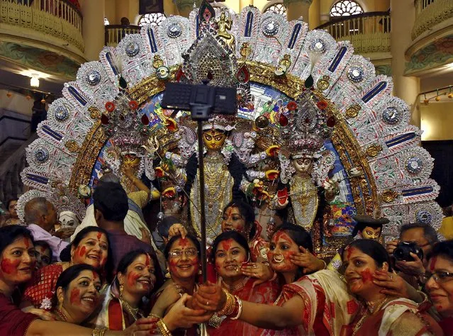Hindu women use a selfie stick to take pictures after worshipping the idol of the Hindu goddess Durga on the last day of the Durga Puja festival in Kolkata, India, October 22, 2015. The Durga Puja festival is celebrated from October 19 to 22, which is the biggest religious event for Bengali Hindus. Hindus believe that the goddess Durga symbolises power and the triumph of good over evil. (Photo by Rupak De Chowdhuri/Reuters)
