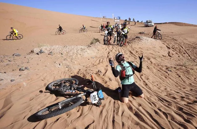 A competitor reacts after crossing a sand dune during Stage 4 of the 13th edition of the Titan Desert 2018 mountain biking race between Boumalne Dades and Merzouga in Morocco on May 2, 2018. The Titan Desert 2018 is 600 kilometre mountain bike race completed over six days, snaking between Boumalne Dades, at the foot-slopes of the High Atlas summits, and Erfoud, an oasis town in the Sahara Desert. (Photo by Franck Fife/AFP Photo)