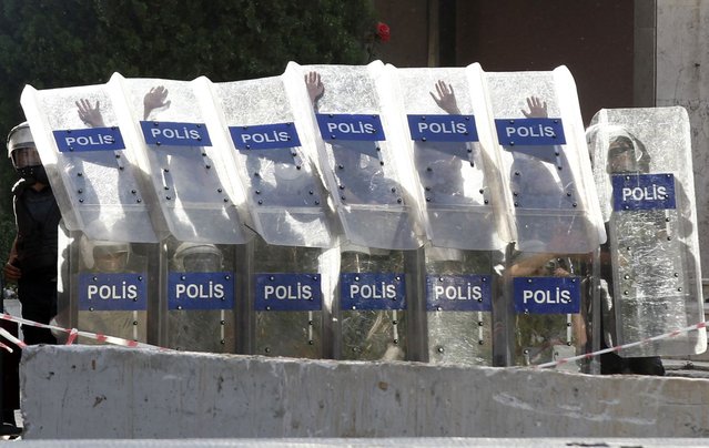Turkish riot police protect themselves with their shields during clashes with protesters as they protest against Turkey's Prime Minister Tayyip Erdogan and his ruling AK Party in central Ankara June 2, 2013. (Photo by Umit Bektas/Reuters)