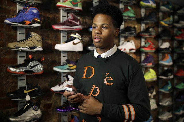 In this January 12, 2015 photo “Sneaker PAwn” proprietor Chase Reed looks up from his phone while talking to a reporter at his store in the Harlem section of New York. Reed makes loans against high end athletic athletic shoes left as collateral. (Photo by Seth Wenig/AP Photo)