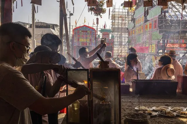 Worshippers burn incense at a temple during the Bun Festival in Cheung Chau Island in Hong Kong, Friday, May 26, 2023. (Photo by Louise Delmotte/AP Photo)