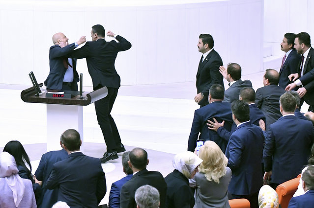 Turkey's AK Party lawmaker Alpay Ozalan, second left, scuffles with Workers' Party of Turkey (TIP) lawmaker Ahmet Sik, during the extraordinary session of the Turkish Grand National Assembly to debate the case of jailed opposition lawmaker Can Atalay, in Ankara, Turkey, Friday, August 16, 2024. (Photo by DIA Images via AP Photo)
