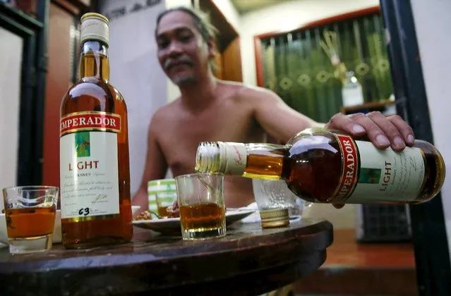 A resident pours a shot of an Emperador brandy inside a house in Manila, Philippines, December 8, 2015. Beam Suntory agreed to sell its Spain-based brandy and sherry business to Emperador of the Philippines for 275 million euros, the companies said on November 30. (Photo by Romeo Ranoco/Reuters)