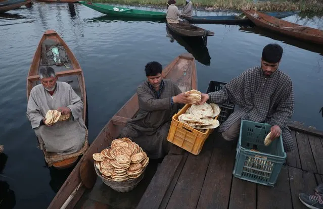 A roadside vendor sells the local bread to Kashmiri boatmen on the interior of Dal Lake in Srinagar, Kashmir, India, 10 March 2021. Kashmiri boatmen work to earn their livelihood mostly by selling vegetables produced in the lake, ferrying tourists, and cleaning the lake of weeds while women are often seen selling the fish caught by their men. (Photo by Farooq Khan/EPA/EFE)