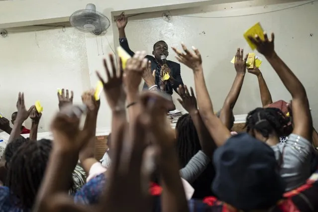 Congregants wave their hands in praise as a Protestant pastor leads a prayer at a church in Port-au-Prince, Haiti, Friday, June 2, 2023. (Photo by Ariana Cubillos/AP Photo)