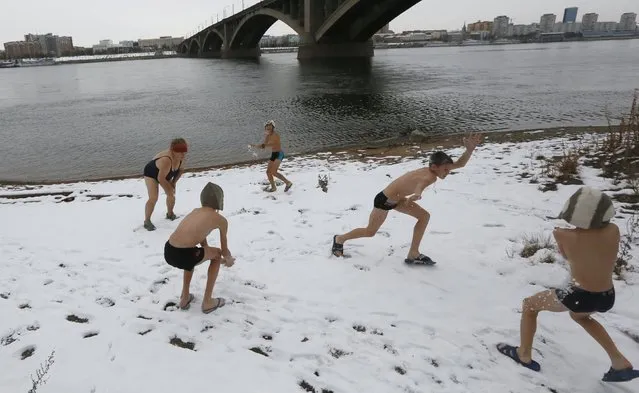 Young members of the Cryophile winter swimming club throw snowballs, their trainer to the left, on the banks of the Yenisei River before swimming in Russia's Siberian city of Krasnoyarsk, October 25, 2015. The air temperature was around minus 1 degree Celsius. A winter swimming club in the Siberian city of Krasnoyarsk gathers young and old from all walks of life. They share a love of bracing, cold water, in air temperatures that can reach minus 30 degrees Celsius or lower. With a small wooden clubhouse on the banks of the Yenisei River, the Cryophile club - named after organisms that thrive in the cold - has about 300 members. (Photo by Ilya Naymushin/Reuters)