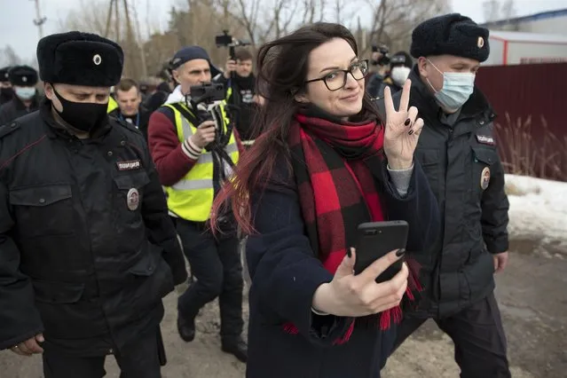 Activist Ksenia Pakhomova, foreground, takes a selfie as police officers detain her at the prison colony IK-2, which stands out among Russian penitentiary facilities for its particularly strict regime, in Pokrov in the Vladimir region, 85 kilometers (53 miles) east of Moscow, Russia, Tuesday, April 6, 2021. (Photo by Pavel Golovkin/AP Photo)