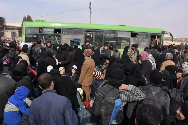 Syrians that evacuated the eastern districts of Aleppo gather to board buses, in a government held area in Aleppo, Syria in this handout picture provided by SANA on November 29, 2016. (Photo by Reuters/SANA)