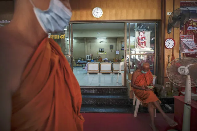 Buddhist monks stand outside a room where devotees are lying inside coffins during a “live funeral” ritual at Bangna Nai temple in Bangkok, Thailand, 13 February 2021. (Photo by Diego Azubel/EPA/EFE)