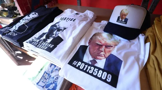 T-shirts and hats with an image depicting the mugshot of former U.S. President Donald Trump are pictured after being printed at the Y-Que printing store in Los Angeles, California, U.S., August 26, 2023. (Photo by Mario Anzuoni/Reuters)