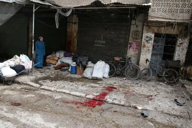 A woman stands near the blood stained ground after strikes on rebel-held besieged al-Zebdieh district, in Aleppo Syria December 5, 2016. (Photo by Abdalrhman Ismail/Reuters)