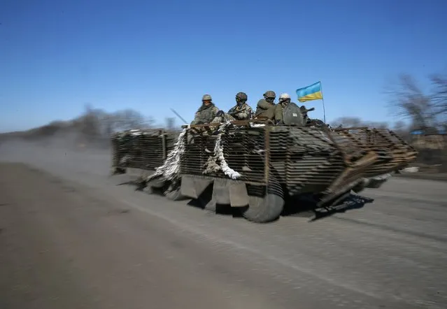 Members of the Ukrainian armed forces ride an armoured personnel carrier near Artemivsk, eastern Ukraine, February 22, 2015. A senior pro-Russian rebel commander said separatist forces were due to begin withdrawing heavy weapons from the front line in east Ukraine on Sunday, a sign rebels may be prepared to halt their advance as part of an internationally brokered peace deal.  REUTERS/Gleb Garanich (UKRAINE - Tags: POLITICS CIVIL UNREST MILITARY CONFLICT)