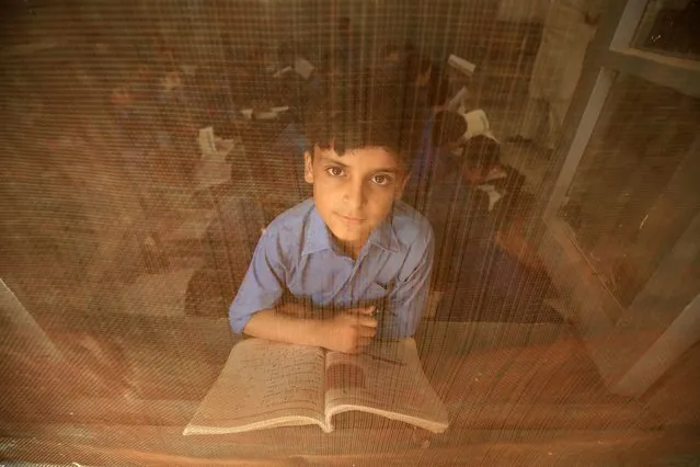 A Pakistani boy poses for a photograph while attending a class during the International Literacy Day in Peshawar, Pakistan, 08 September 2023. The International Literacy Day, observed annually on 08 September, is celebrated this year under the theme of 'Promoting literacy for a world in transition: Building the foundation for sustainable and peaceful societies' according to the United Nations Educational, Scientific and Cultural Organization (UNESCO). (Photo by Bilawal Arbab/EPA)