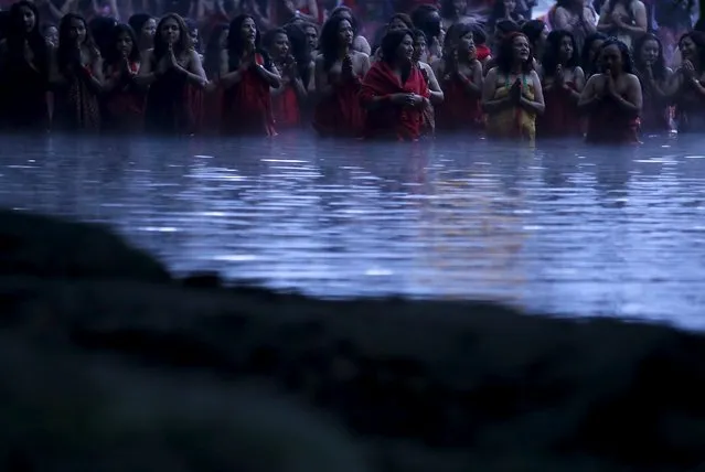 Devotees offer prayers as they submerge themselves in the river before taking a holy bath at Saali River in Sankhu during the Swasthani Brata Katha festival in Kathmandu, Nepal, January 24, 2016. During the month long festival, devotees recite one chapter of a Hindu tale daily from the 31-chapter sacred Swasthani Brata Katha book that is dedicated to God Madhavnarayan and Goddess Swasthani, alongside various other gods and goddess and the miraculous feats performed by them. (Photo by Navesh Chitrakar/Reuters)