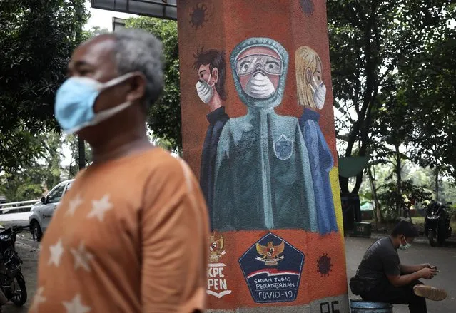 A man walks past a coronavirus-themed mural in Jakarta, Indonesia, Tuesday, June 8, 2021. The world's fourth-most populous country, with about 275 million people, has reported more coronavirus cases than any other Southeast Asian country. (Photo by Dita Alangkara/AP Photo)