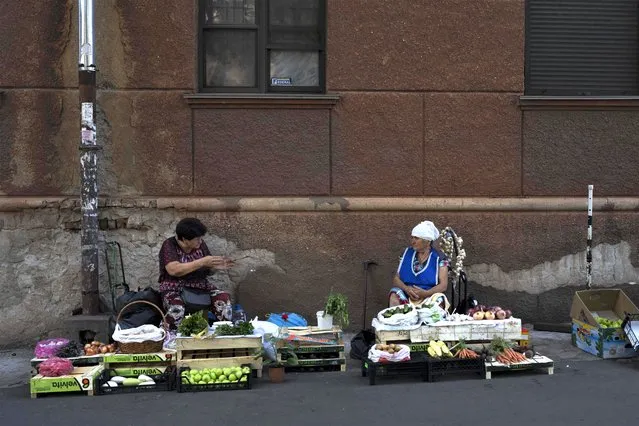Two street vendors chat in Odesa, Ukraine, Monday, July 24, 2023. In just a week, Russia has fired more than 125 missiles and drones at the Odesa region, hitting the historic city center that had been largely spared since the beginning of the war. (Photo by Jae C. Hong/AP Photo)