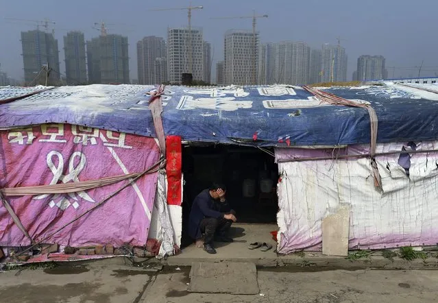 A farmer rests at a shelter near a construction site of a new residential complex in Hefei, Anhui province, March 16, 2015. China's property sales in the first two months of 2015 dropped by the most in three years amid a glut of housing supply, and real estate investment growth eased. (Photo by Reuters/Stringer)