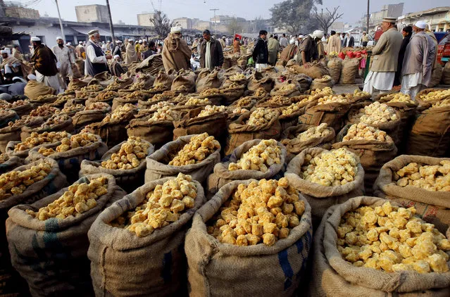 In this December 7, 2015, file photo, vendors visit a wholesale market to buy Jaggery, in Peshawar, Pakistan.  Pakistan says it will seek a bailout loan from the International Monetary Fund to address a mounting balance of payments crisis, Finance Minister Asad Umar said Monday. (Photo by Muhammad Sajjad/AP Photo)