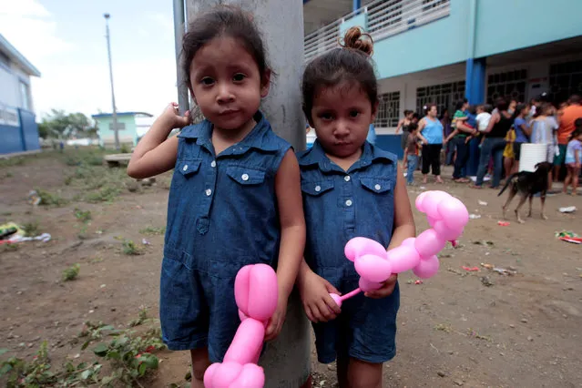 Twins wait to receive toys from the government of Nicaragua's President Daniel Ortega, during celebrations ahead of Christmas at the Belen neighborhood in Managua, Nicaragua December 21,2016. (Photo by Oswaldo Rivas/Reuters)