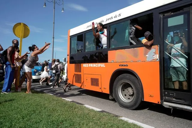 People ask passengers of a bus to join them during a during a protest against and in support of the government, amidst the coronavirus disease (COVID-19) outbreak, in Havana, Cuba on July 11, 2021. (Photo by Alexandre Meneghini/Reuters)