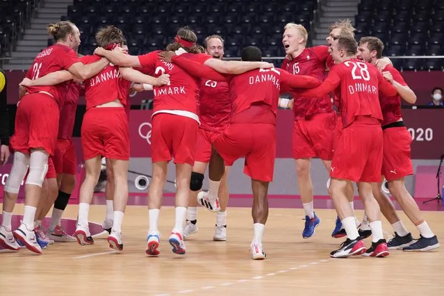 Denmark's team players celebrate as they won the men's semifinal handball match between Spain and Denmark at the 2020 Summer Olympics, Thursday, August 5, 2021, in Tokyo, Japan. (Photo by Pavel Golovkin/AP Photo)