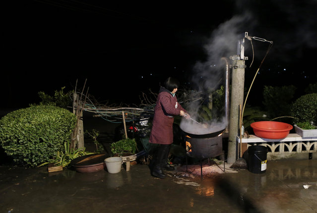 A local villager cooks outside as she prepares a traditional ethnic Tujia wedding feast for about 2000 guests in during celebrations marking the Lunar New Year, in Ziqiu town, Changyang county of China’s Hubei province, February 14, 2016. (Photo by Jason Lee/Reuters)