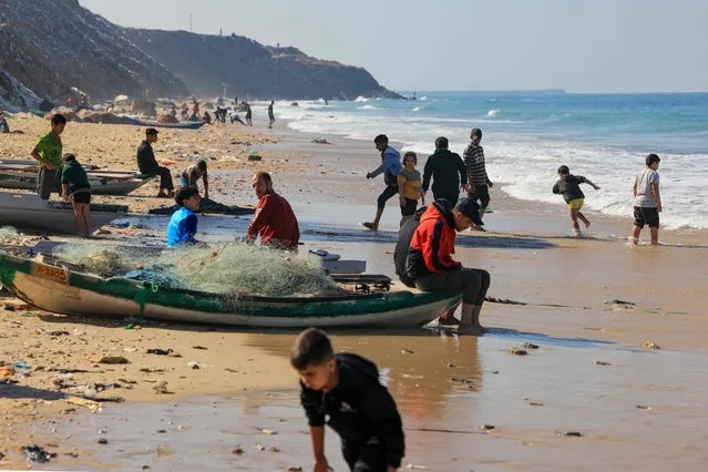 Palestinians gather on the beach in Deir el-Balah, in the central Gaza Strip on November 30, 2023, on the seventh day of a truce between Israel and Hamas. The warring parties have agreed a pause in fighting to allow time for the militant group to release Israeli hostages in exchange for Palestinian prisoners. (Photo by Mahmud Hams/AFP Photo)