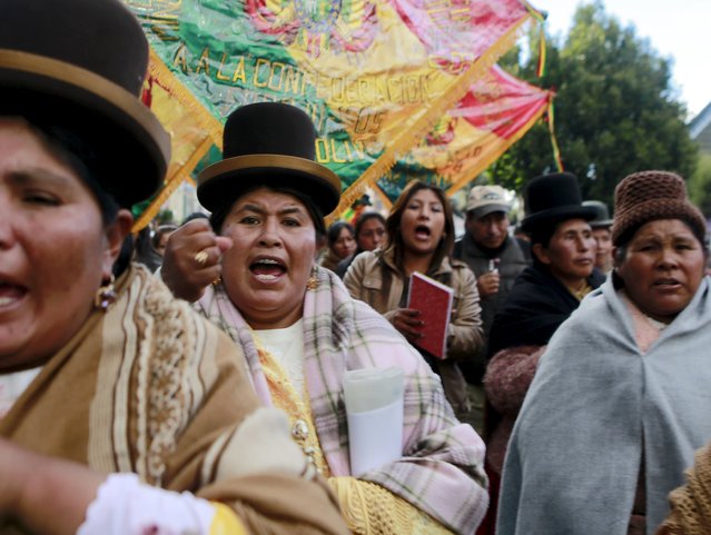 Aymara women protest next to burned municipal offices, after a group of protesters occupied and set fire to it, in El Alto, in the outskirts of La Paz, February 17, 2016. (Photo by David Mercado/Reuters)