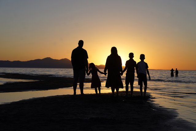 People gather at the receding edge of the Great Salt Lake to watch the sunset on June 13, 2021, near Salt Lake City. The lake has been shrinking for years, and a drought gripping the American West could make this year the worst yet. (Photo by Rick Bowmer/AP Photo)