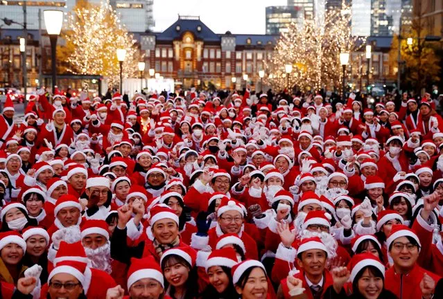 Participants wearing Santa Claus outfits pose for photos before their event to hand out gifts and clean up the street to celebrate the upcoming Christmas season in Tokyo, Japan on December 22, 2023. (Photo by Kim Kyung-Hoon/Reuters)
