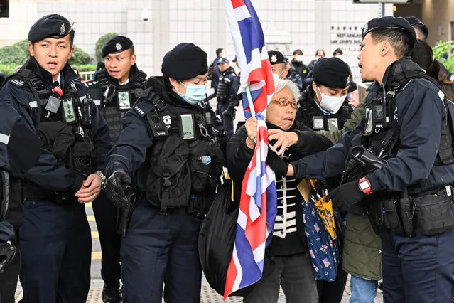Policemen stop activist Alexandra Wong (C), also known as Grandma Wong, as she carries Britain's Union Jack outside the West Kowloon court ahead of the trial of pro-democracy media tycoon Jimmy Lai in Hong Kong on December 22, 2023. A Hong Kong court on December 22 rejected jailed pro-democracy tycoon Jimmy Lai's bid to throw out a charge of seditious publication in a trial that has attracted international attention. (Photo by Peter Parks/AFP Photo)