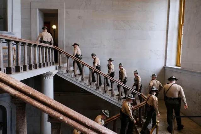 Tennessee State Troopers climb the steps of the rotunda of the Tennessee State Capitol, ahead of the the start of the legislative session months after the Covenant School shooting and protests rocked the state capitol in Nashville, Tennessee, U.S., January 9, 2024. (Photo by Kevin Wurm/Reuters)